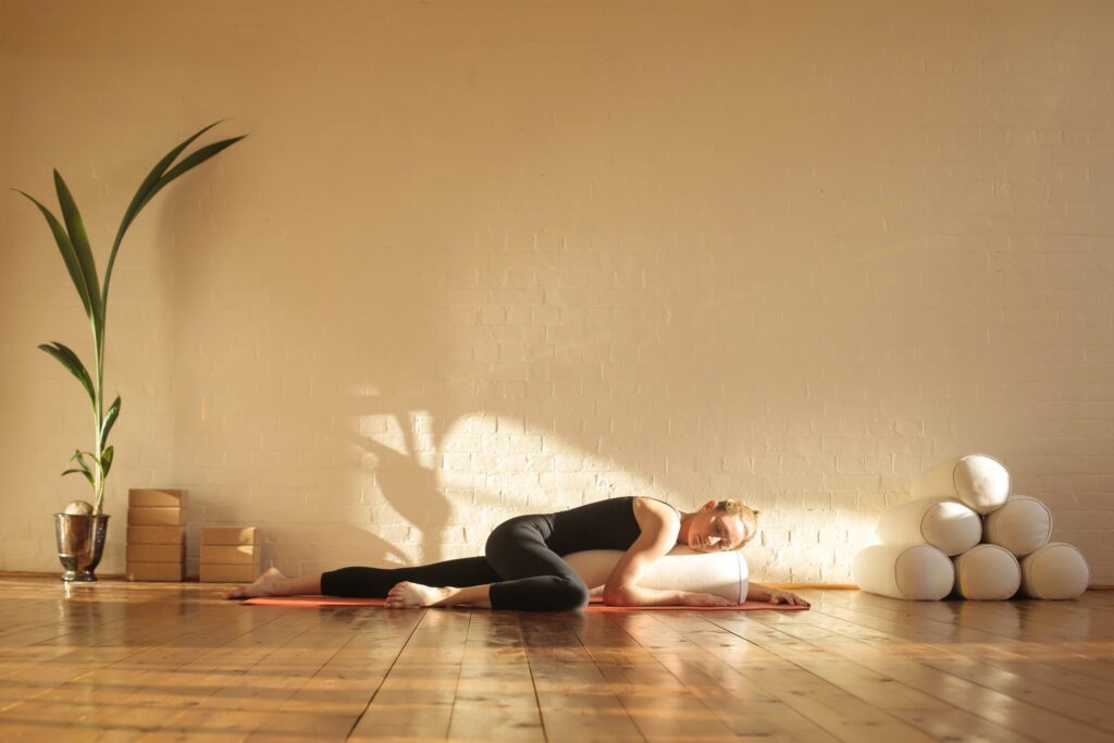 Femme en posture de relaxation avec un bolster