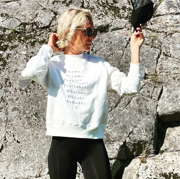 Femme en sweat blanc et leggings noirs dehors