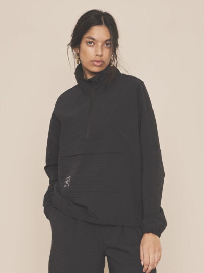 Femme portant une veste légère noire style relax sport avec pantalon assorti noir léger