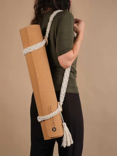 Tapis de yoga en liege tenu par une sangle à tapis de yoga en macramé