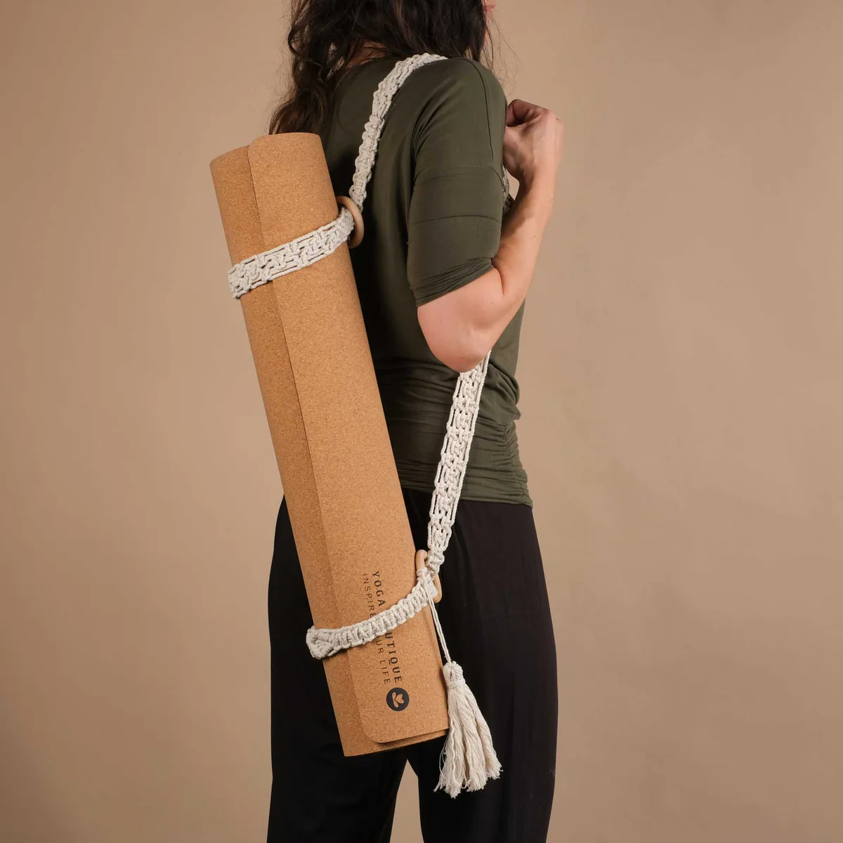 Tapis de yoga en liege tenu par une sangle à tapis de yoga en macramé
