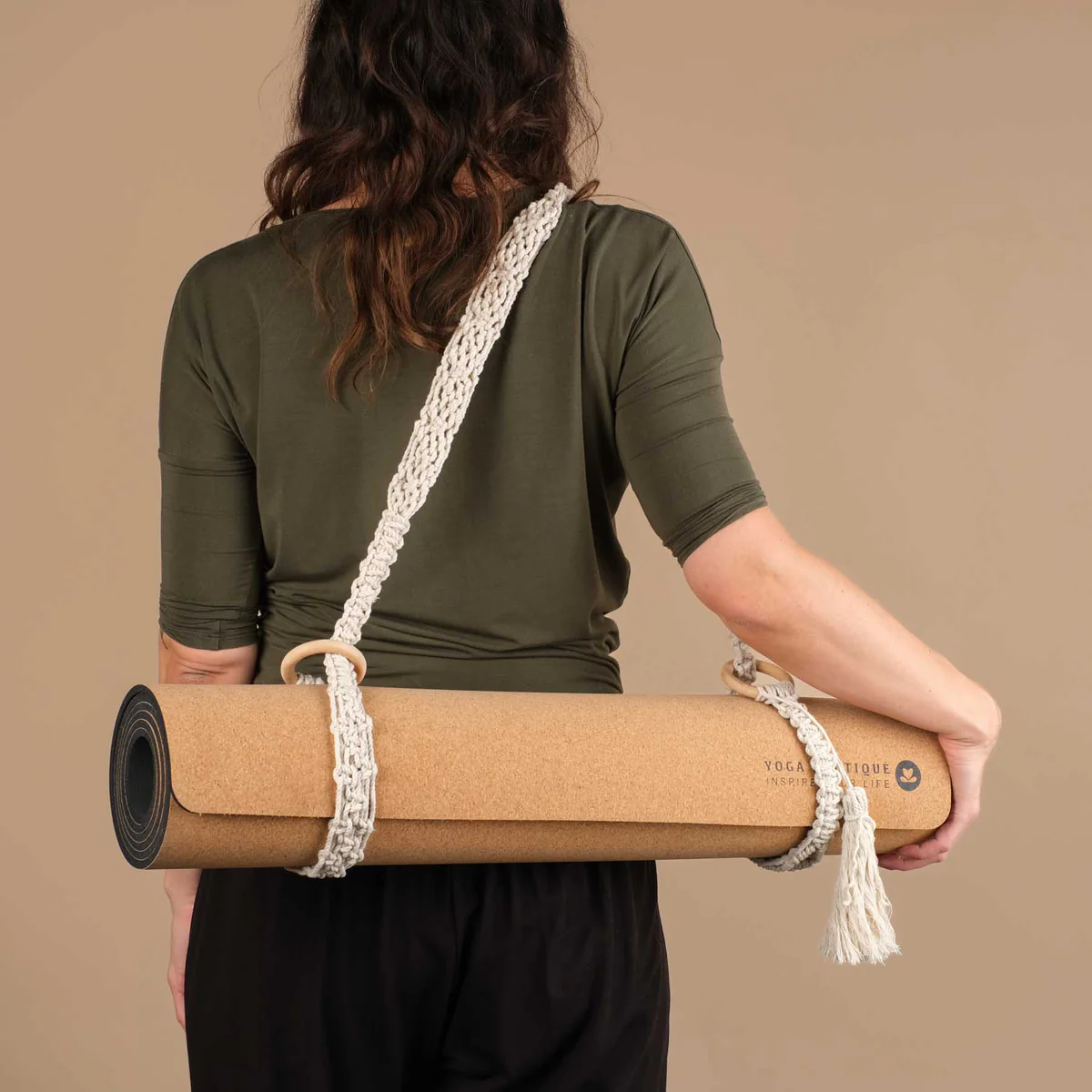 Tapis de yoga en liège porté sur l'épaule