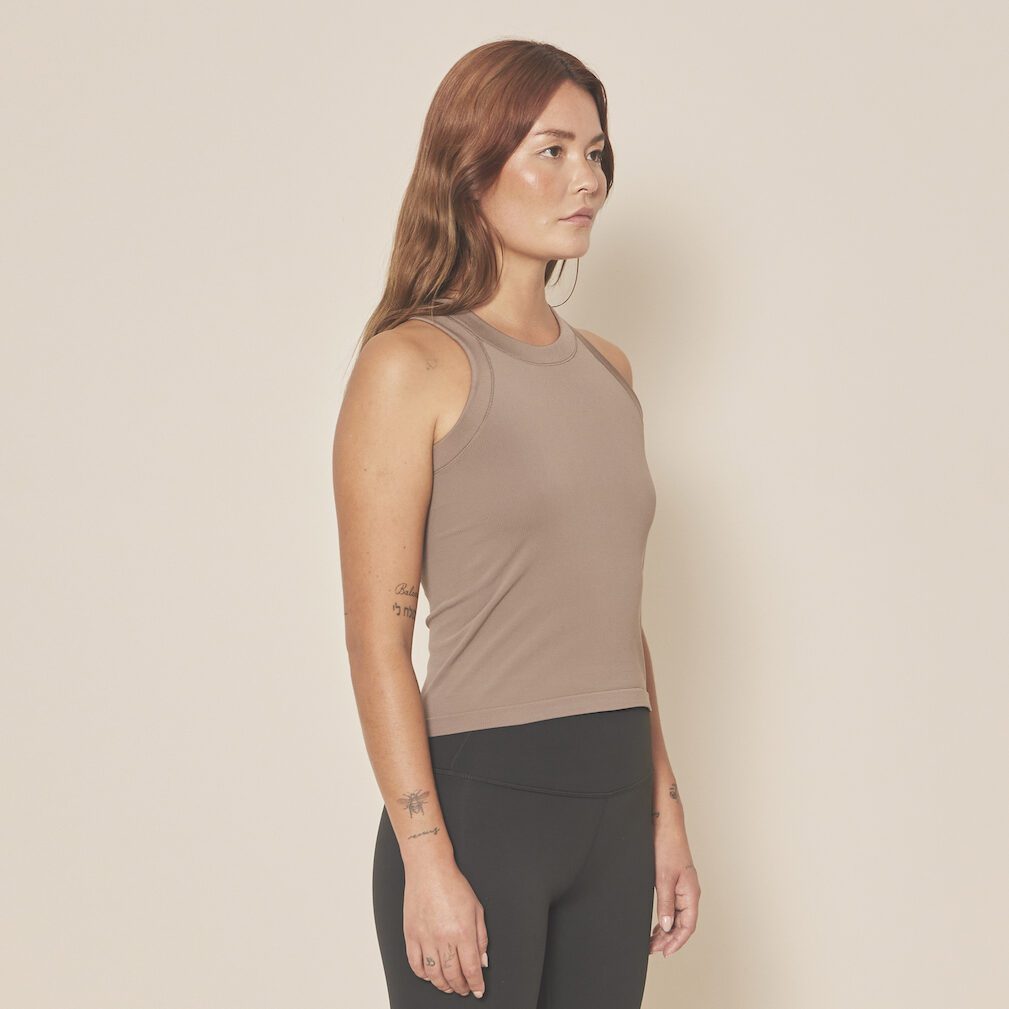 Femme portant un débardeur beige et leggings noirs