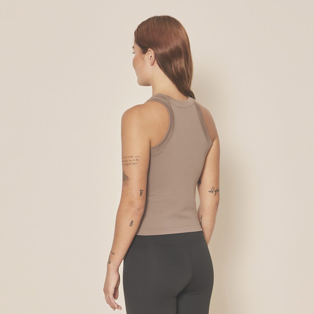 Femme portant un débardeur beige et leggings noirs