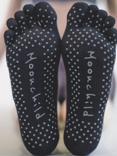 2 pieds chaussés de chaussettes aux semelles antidérapantes pour le pilates et le yoga avec orteils séparés