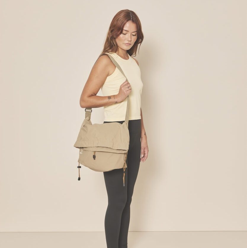 Femme portant un sac bandoulière beige élégant