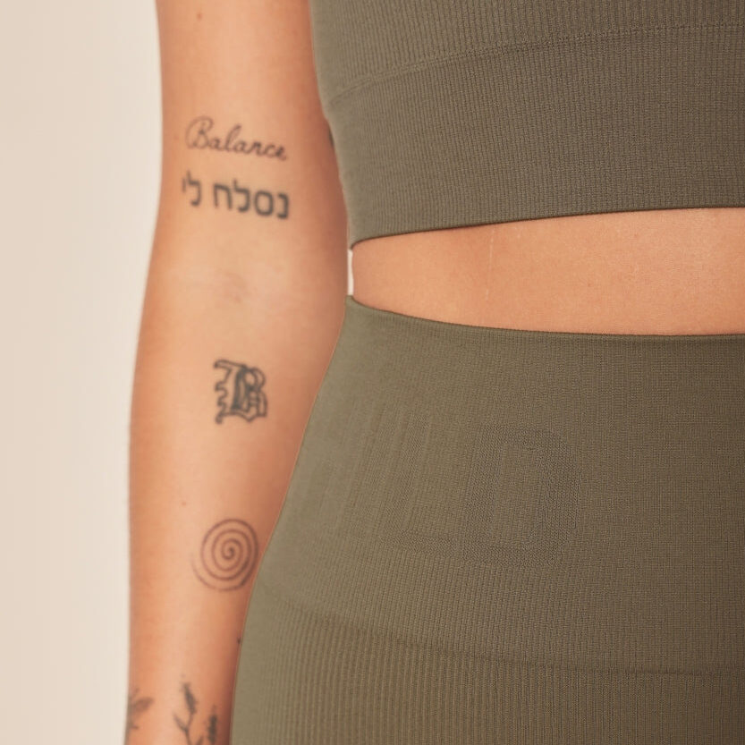 Tenue de sport verte avec tatouages visibles sur le bras