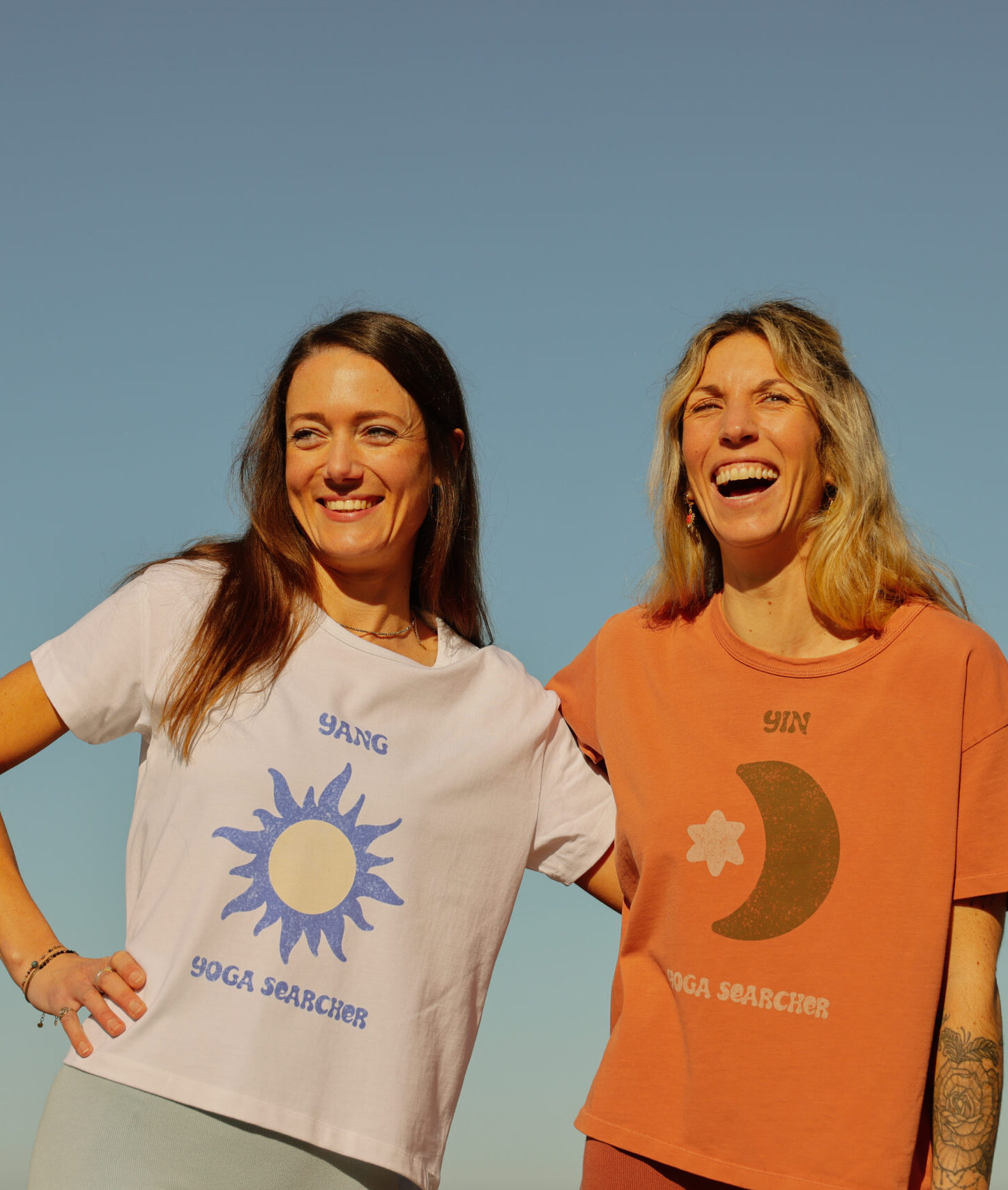 2 femmes portant des tshirts Yin et Yang avec des motifs de couleur blanche et orangé