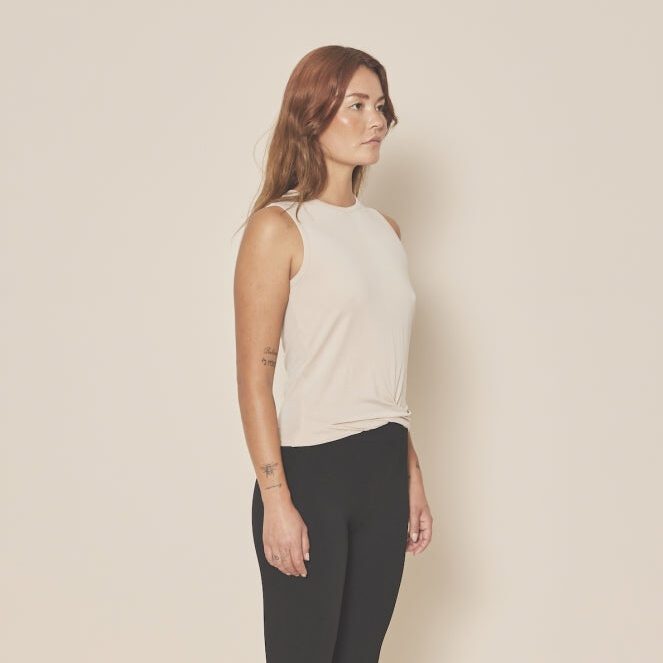 Femme portant débardeur beige et pantalon noir