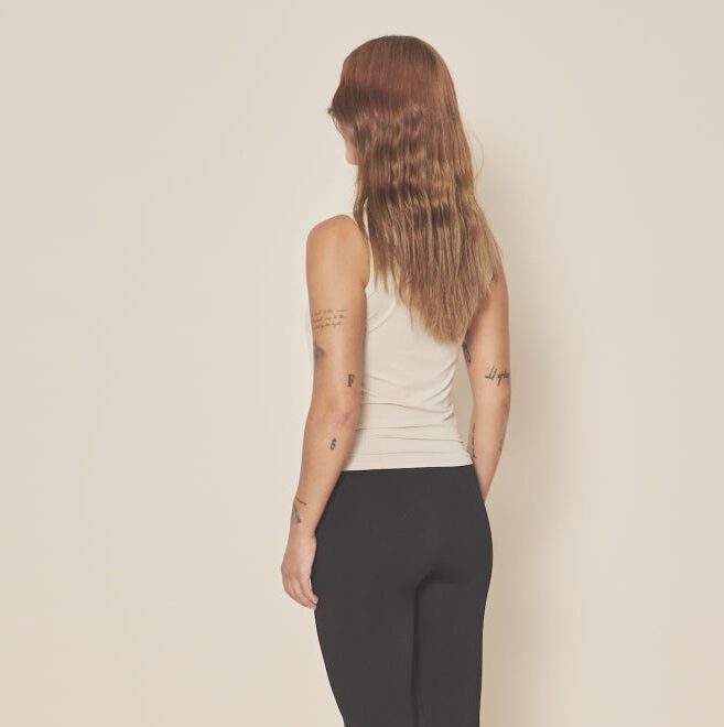 Femme portant débardeur beige et pantalon noir