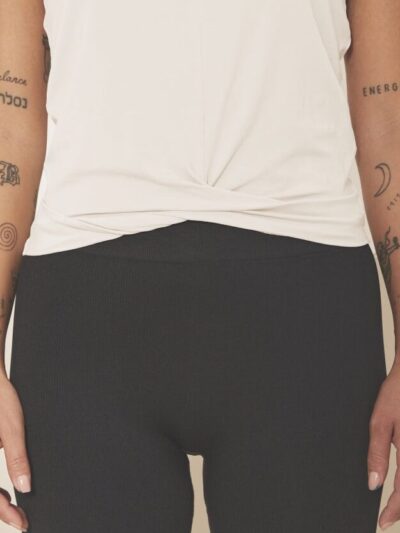 Top sans manches à effet noué sur les hanches écru porté sur un legging noir