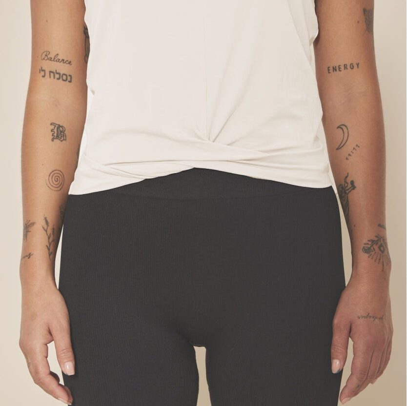 Top sans manches à effet noué sur les hanches écru porté sur un legging noir