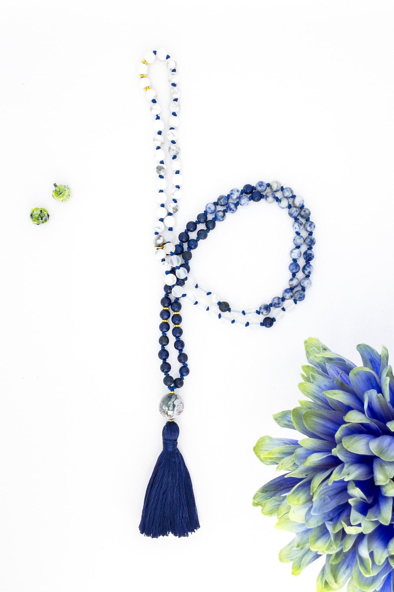 Collier de style mala avec pompon en fils bleus et pendant en agate avec perles semi-précieuses blanches et bleues