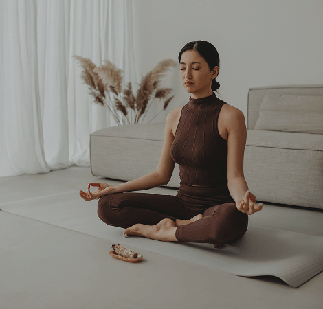 Femme méditant sur un tapis de yoga à domicile