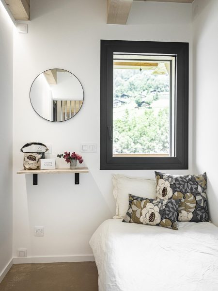 Petite chambre lumineuse avec lit et fenêtre ouverte