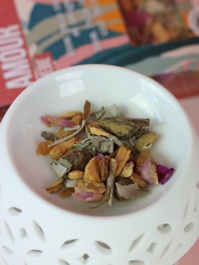 Mélange de plantes et fleurs séchées posées sur un diffuseur d'encens en porcelaine blanche