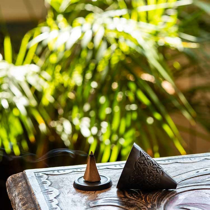 Cône d'encens fumant sur table décorative