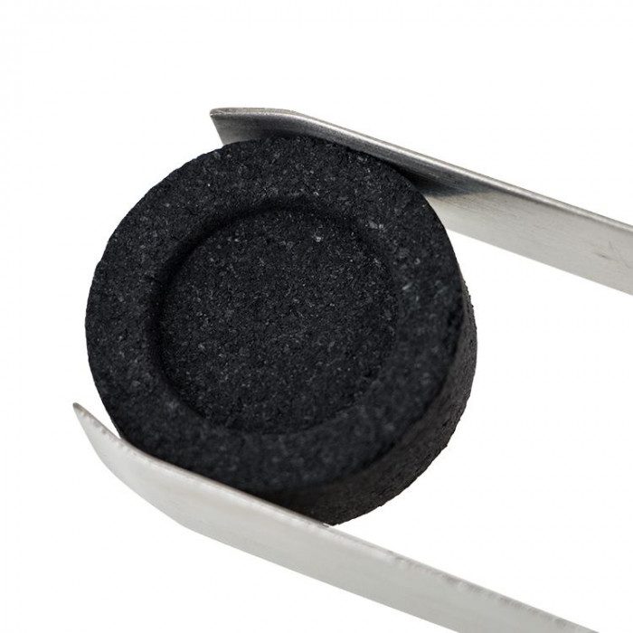 Charbon naturel rond tenu par une pince