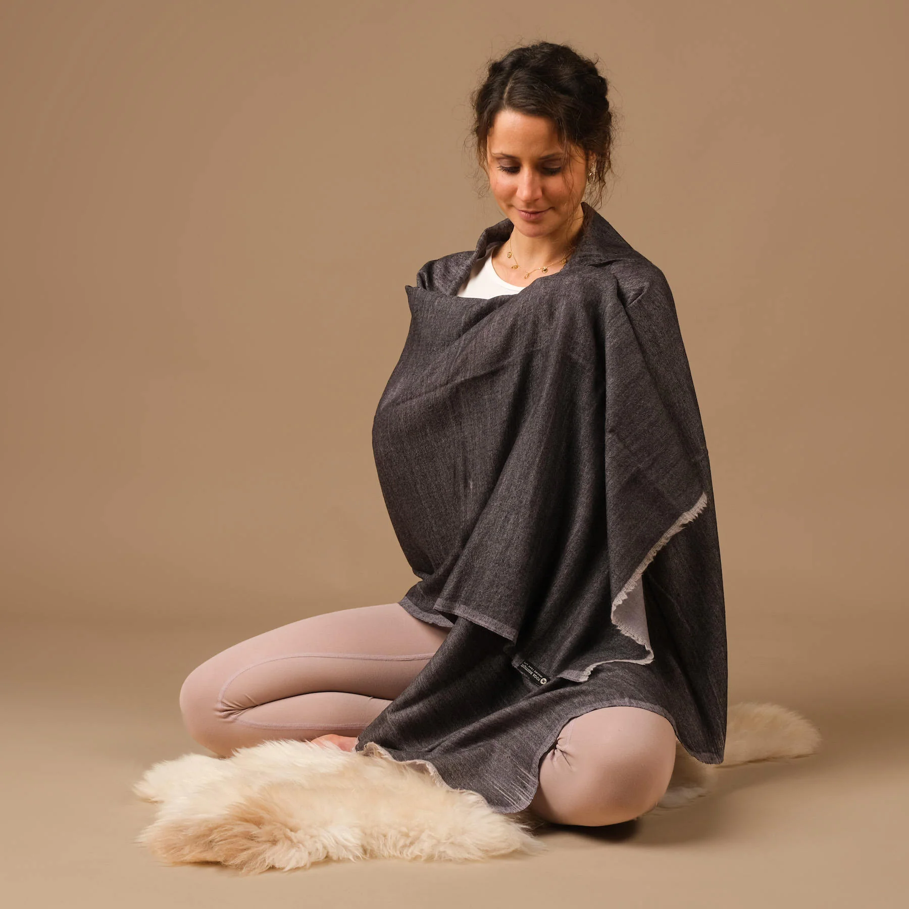 Femme assise portant un châle gris foncé