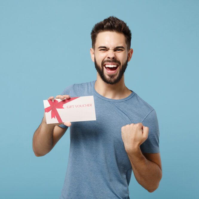 Homme heureux tenant un bon cadeau