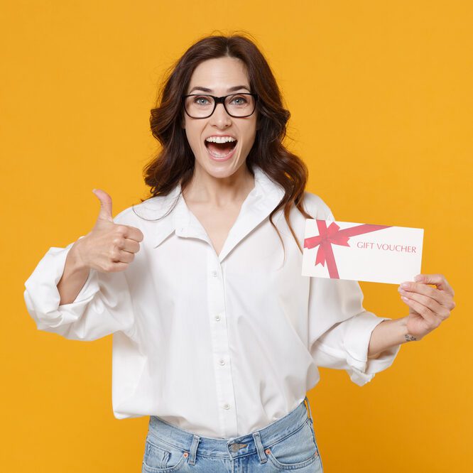 Femme heureuse tenant un bon cadeau