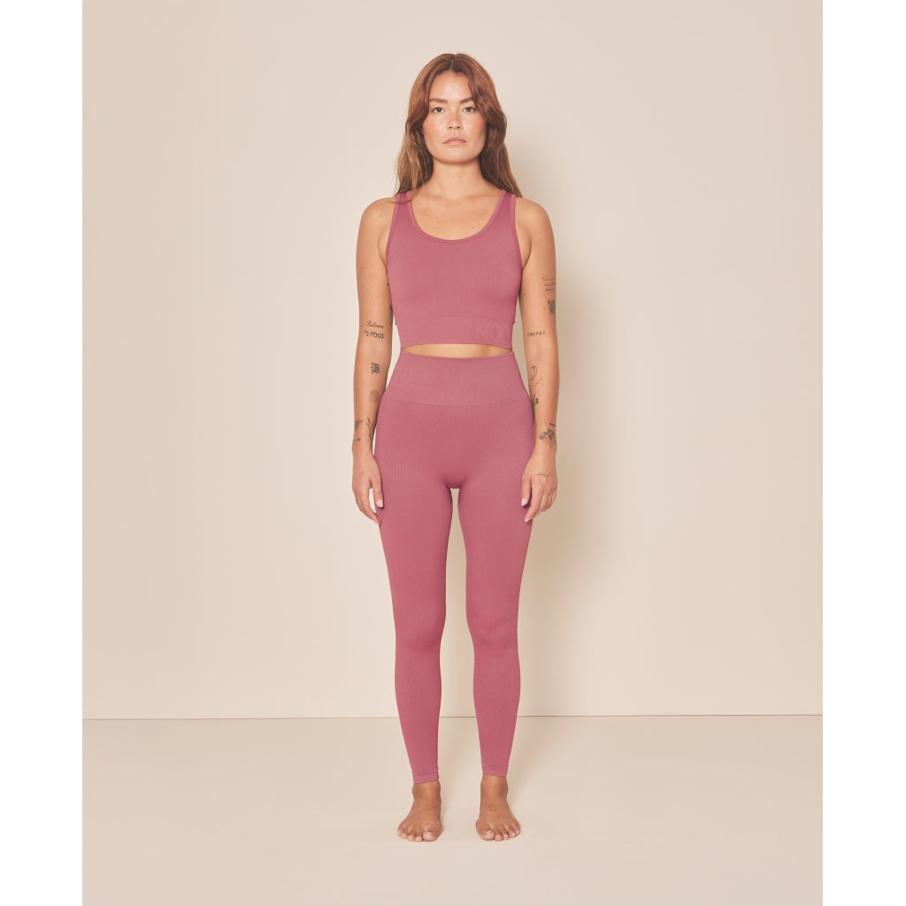 femme qui porte un legging et une brassière rose