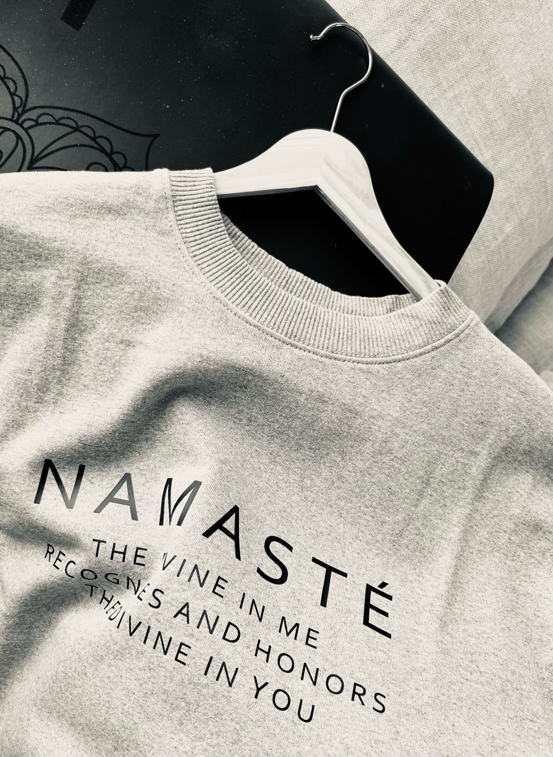 Sweatshirt gris avec écriture noire namaste et définition