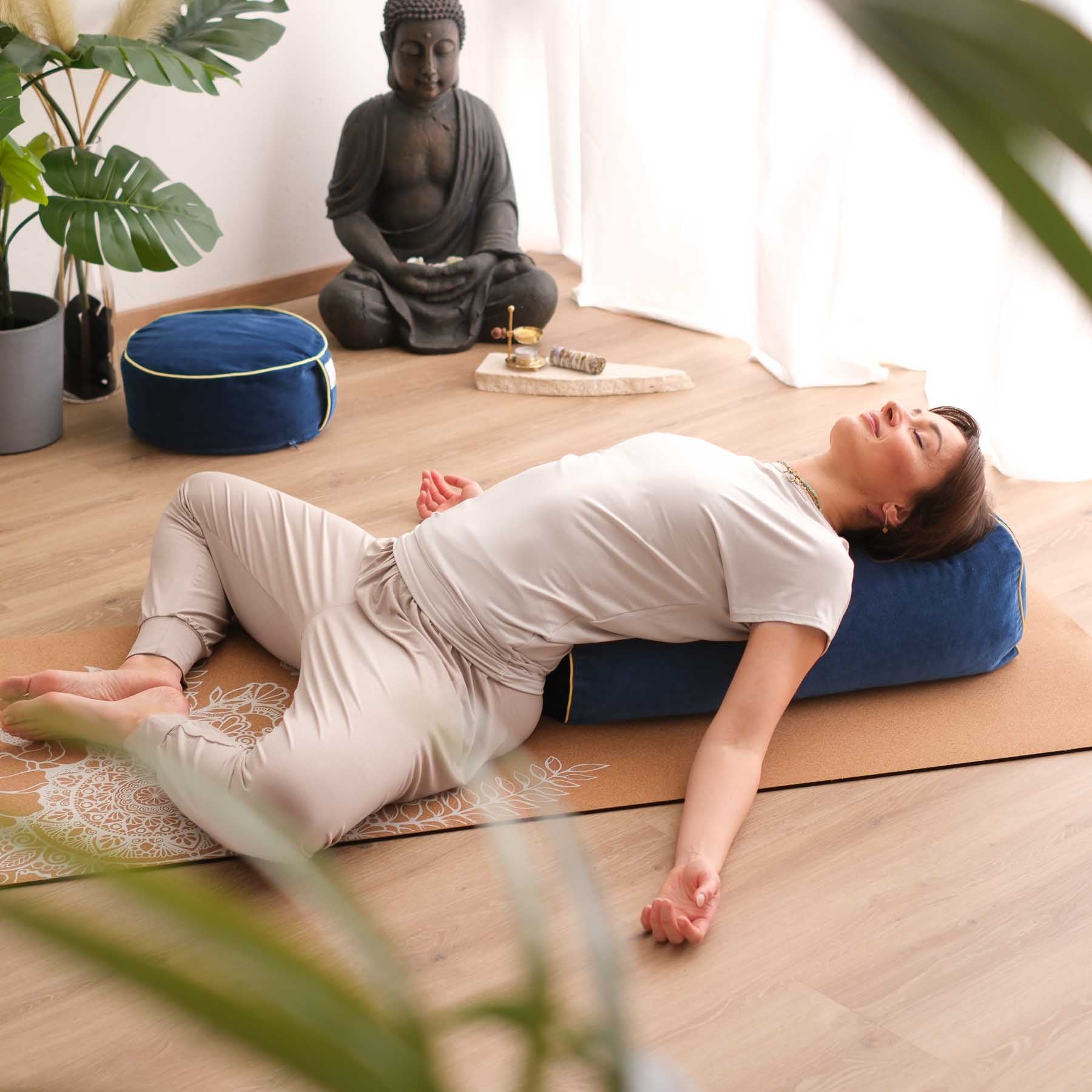 Femme pratiquant le yoga relaxant avec coussin