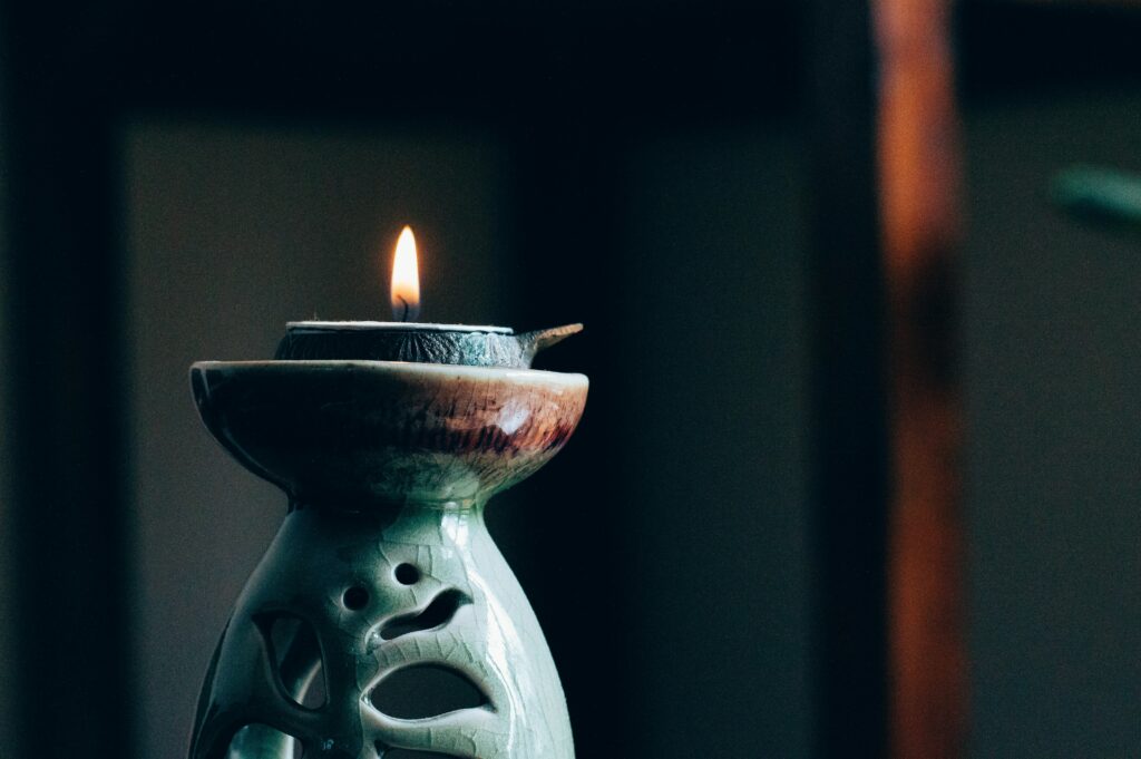 Flamme de bougie et encens sur porte-encens cours de yoga restauratif yin et relaxation