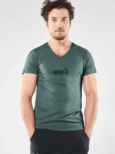 Homme qui porte un T-shirt à manches courtes vert foncé avec une inscription noire en sanskrit qui signifie namaste, et un col V