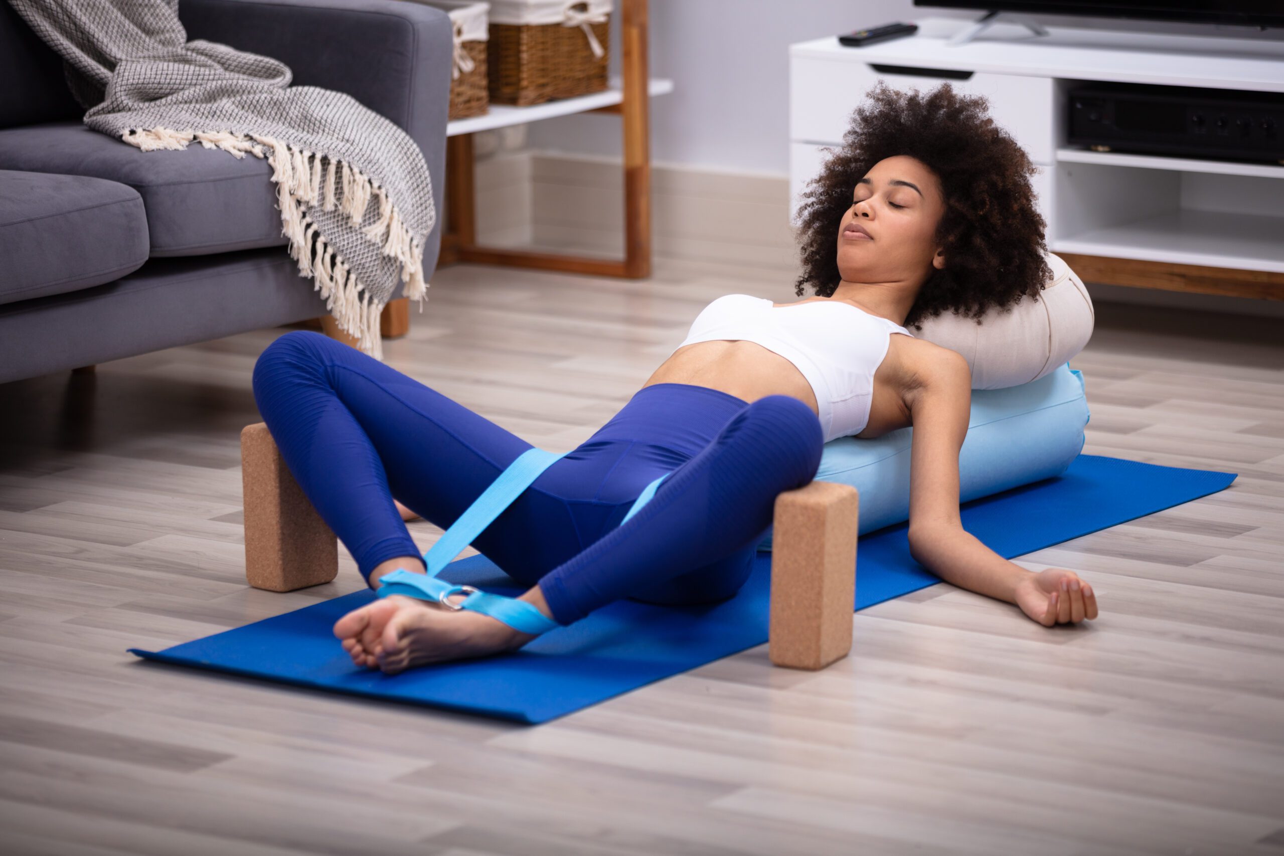 Yogi effectuant une pose avancée de yoga avec l'aide d'un bolster