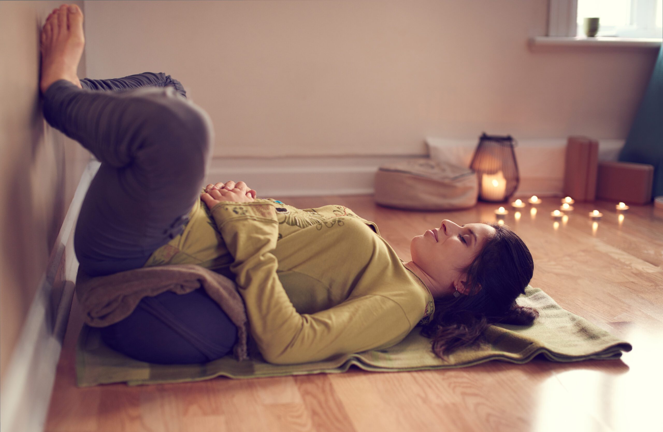 Pratiquante de yoga utilisant un bolster en position de relaxation