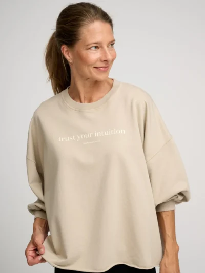 Femme portant un sweat beige à message positif