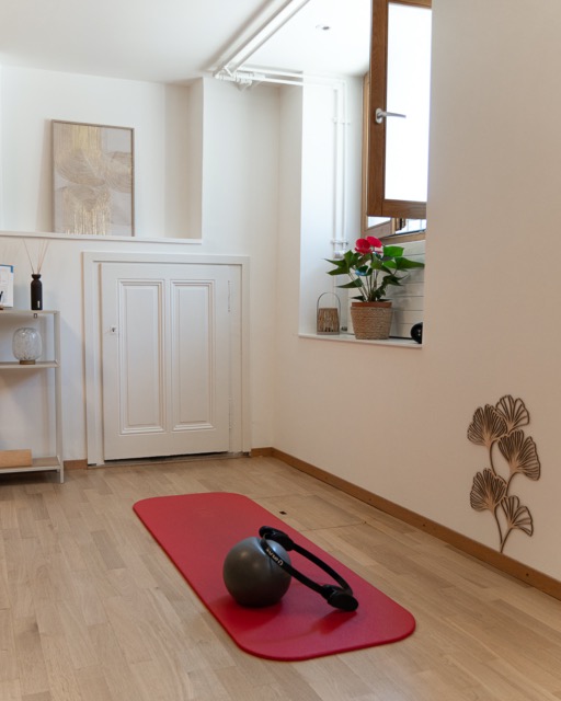 Salle de yoga avec tapis rouge et accessoires