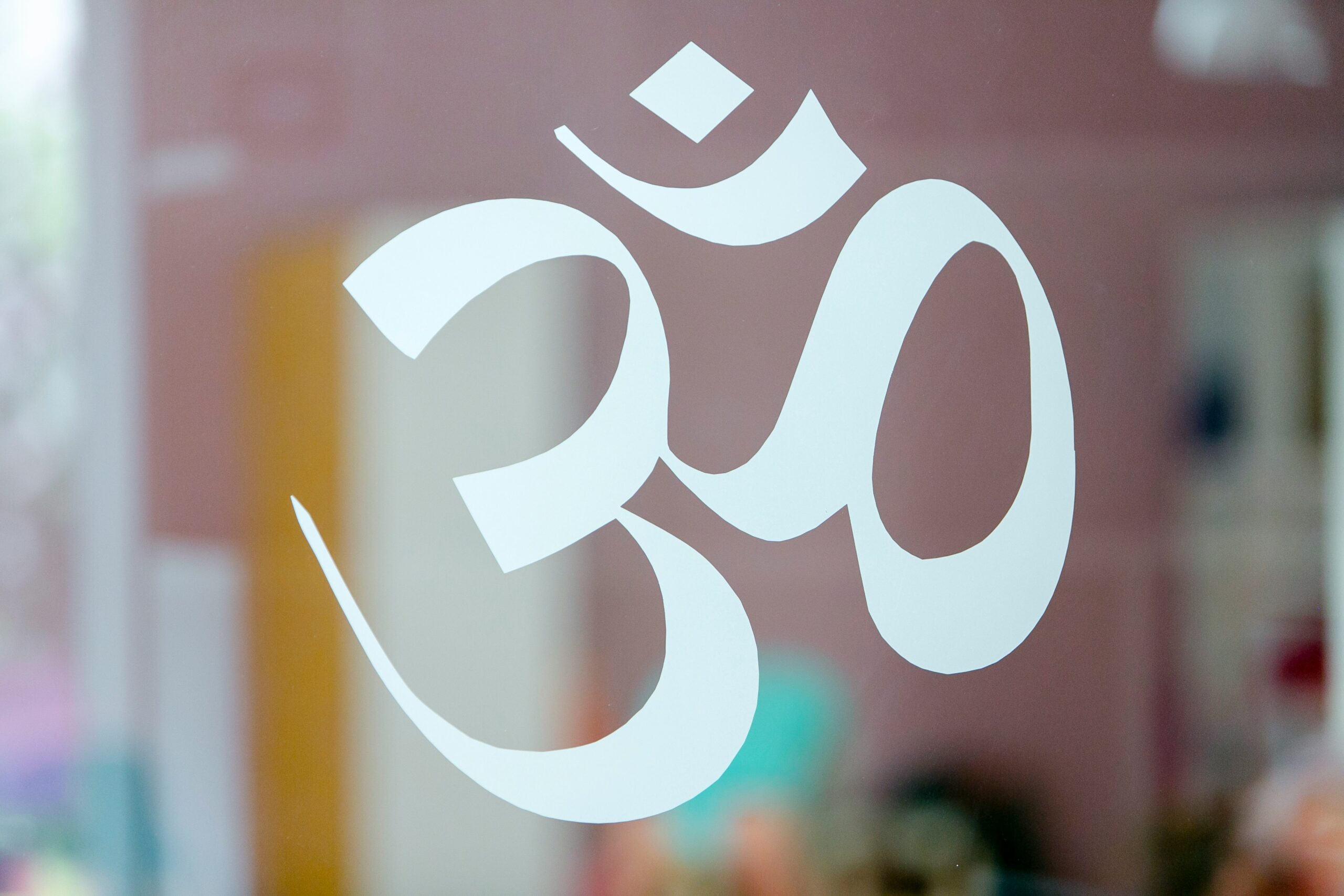 Symbole Om blanc sur vitre floutée