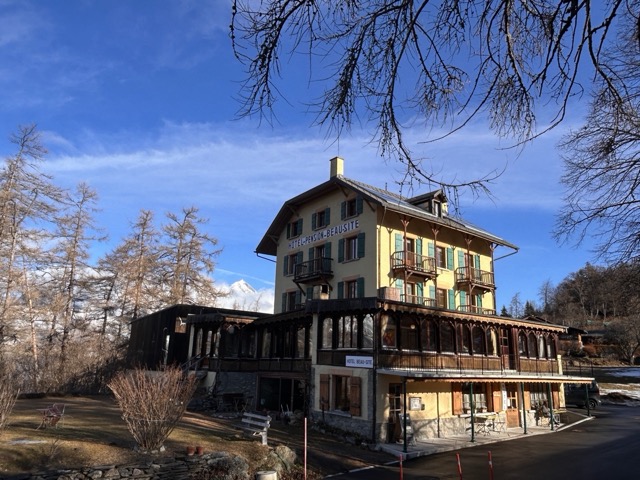 Hôtel de montagne entouré d’arbres sous ciel bleu