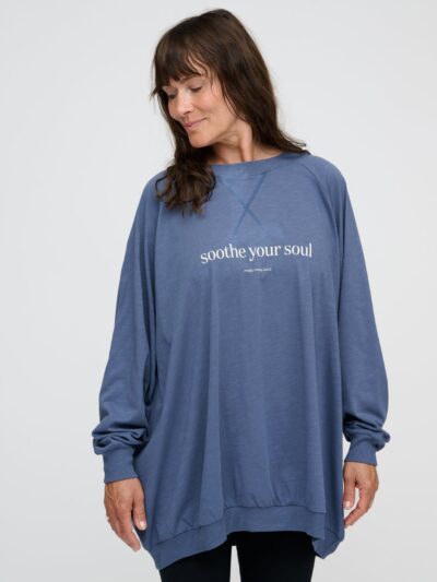 Femme debout porte un sweat-shirt bleu indigo avec inscription blanche devant de forme oversized longue et ample